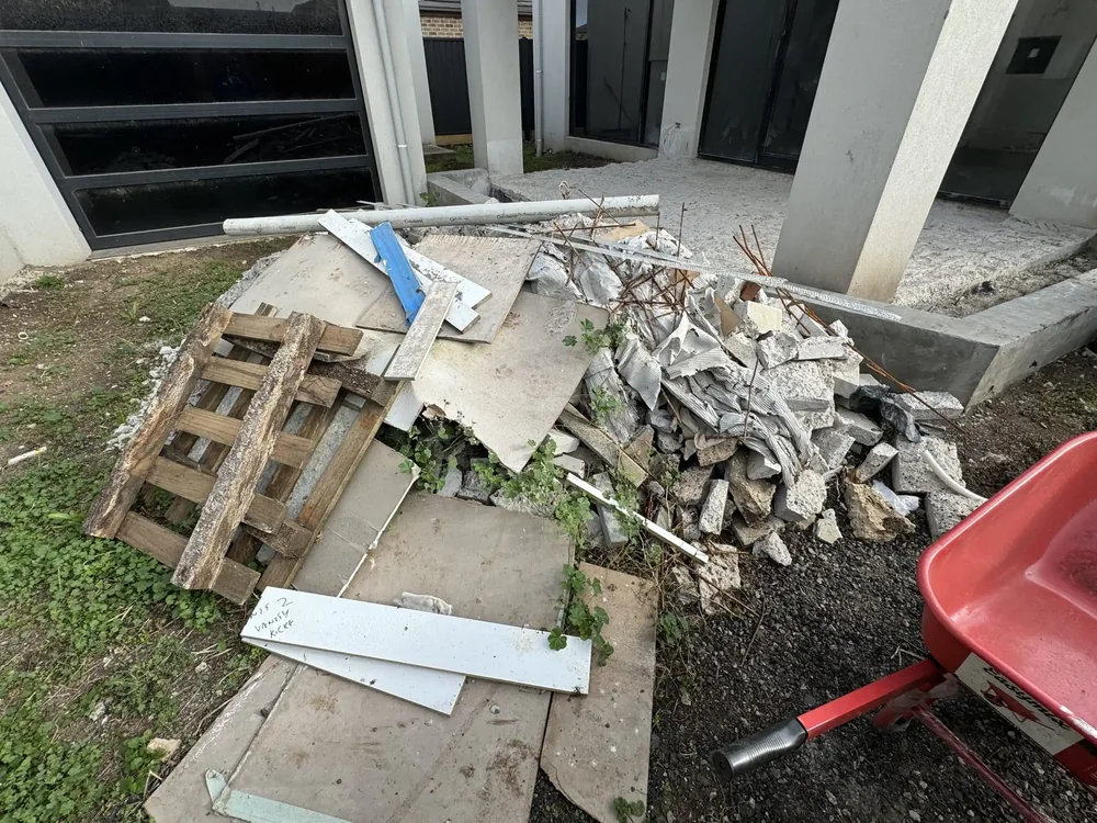 Building site yard before clean-up, with rubble and debris across the ground
