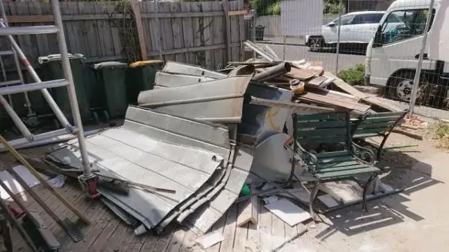 Pile of building waste including sheeting, timber, tiles and rubble before removal