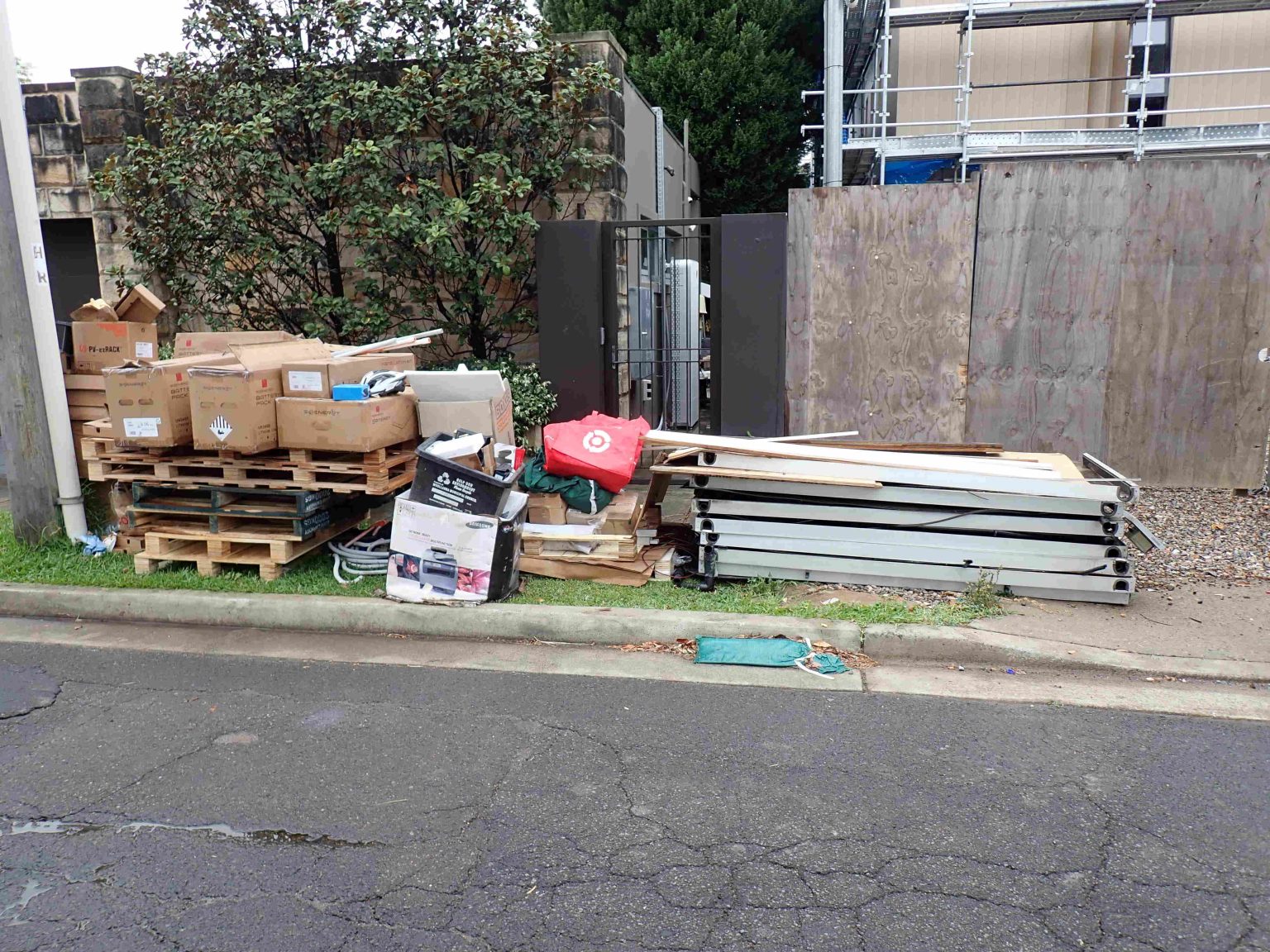 Old solar panels and waste stacked on the kerb, ready for collection and recycling